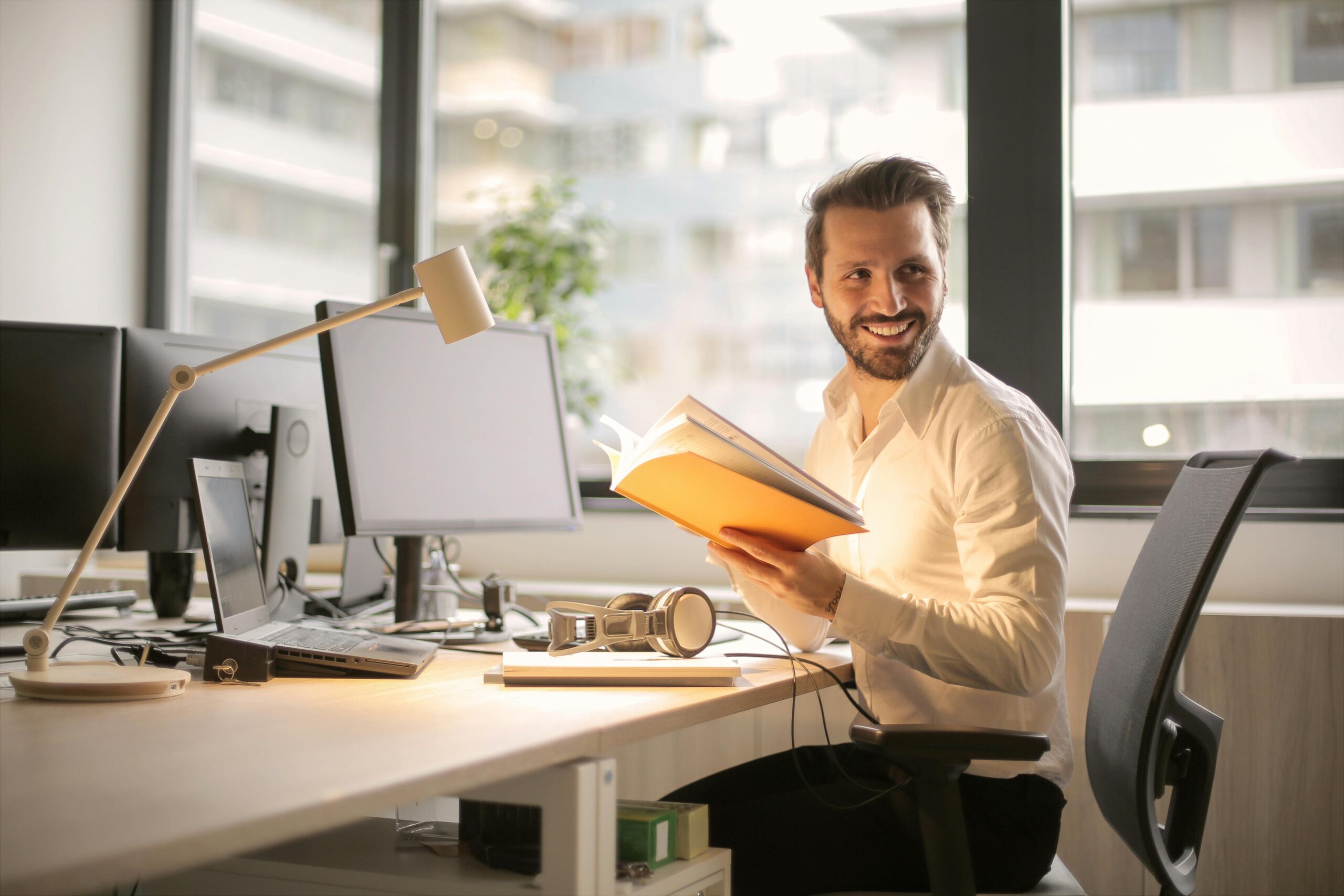 Smiling man working at office desk with computer