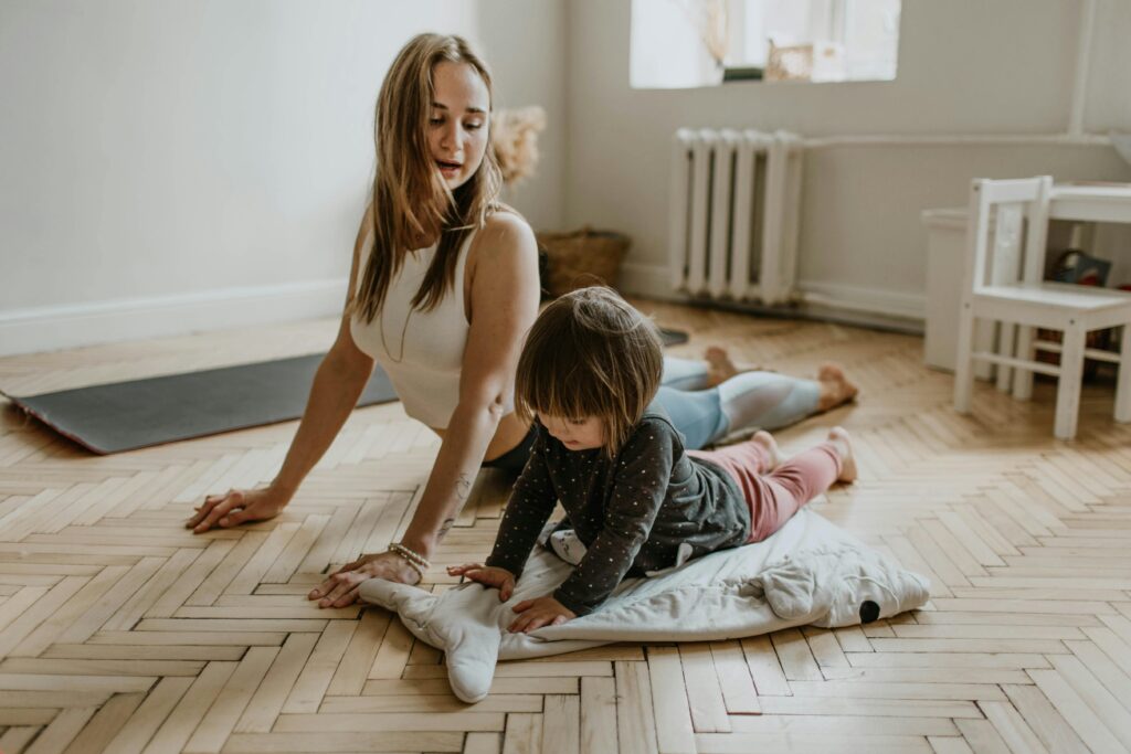 Mom and her young son practicing yoga together in their room, enjoying a shared moment of exercise and mindfulness.