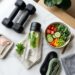 Fitness equipment, food, and water set out on a mat as part of a wellness journey.