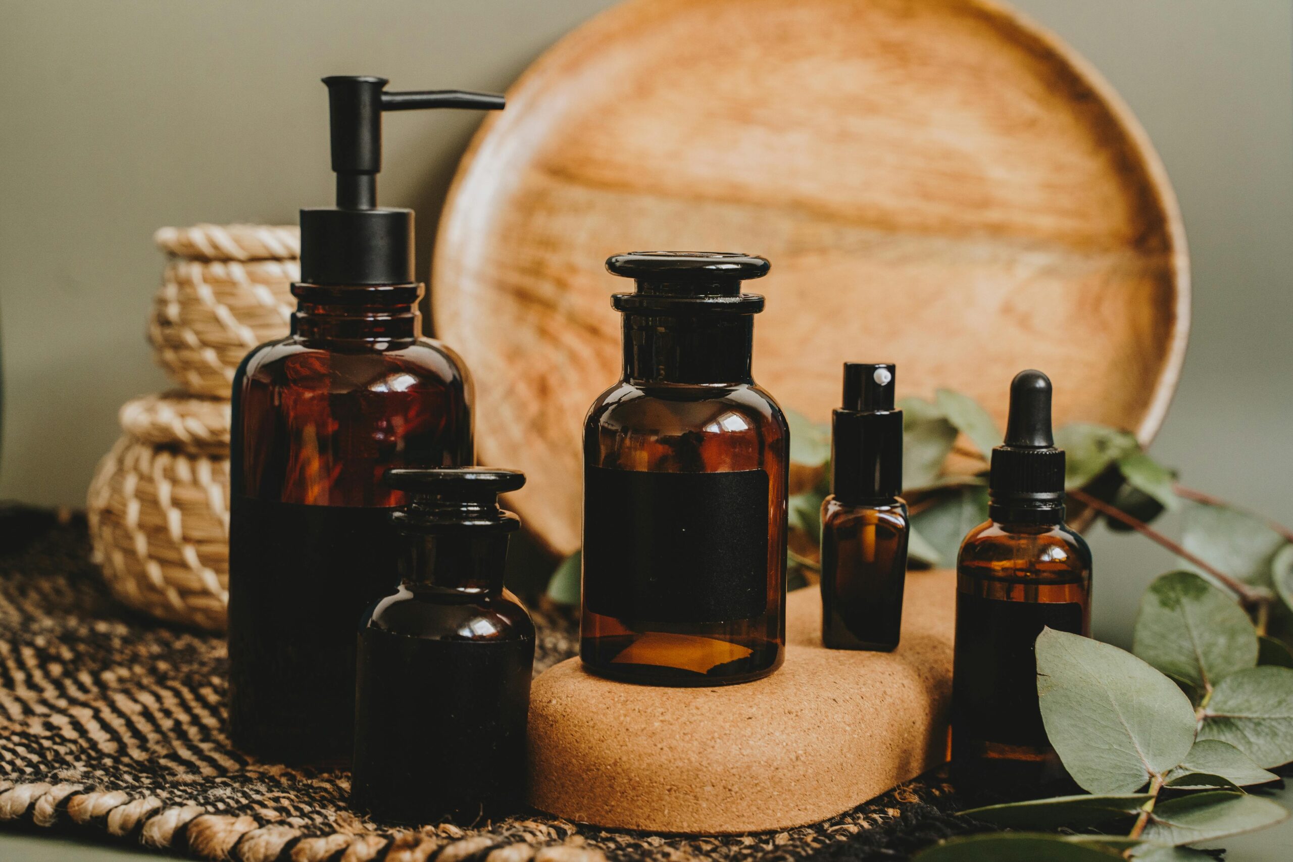 Bottles of essential oils in different sizes arranged on a table.