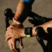 Close up of man cycling, showing wrists and wearing a smart fitness watch