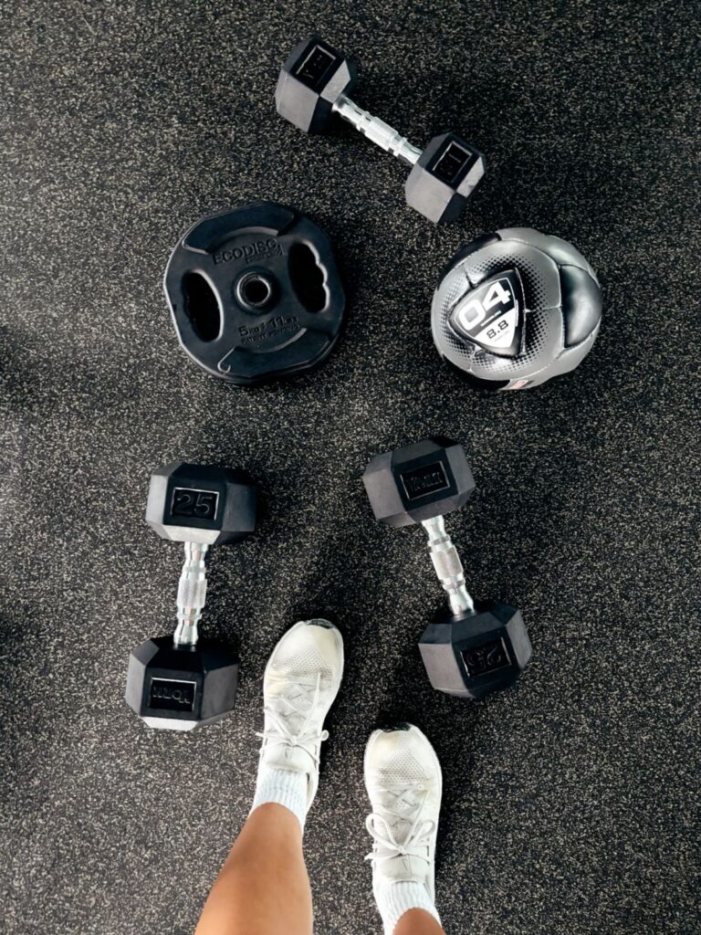 Dumbbells and weights laid out on the ground.