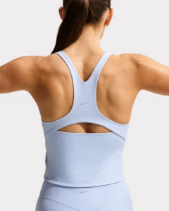 Woman wearing a light blue Nike pilates workout set with a racerback top and matching leggings
