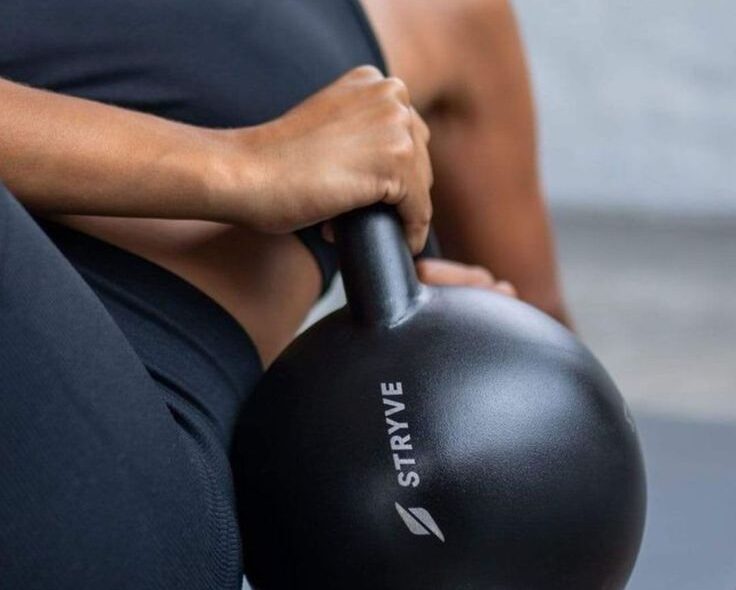 Close cropped image of woman using a kettlebell for a workout