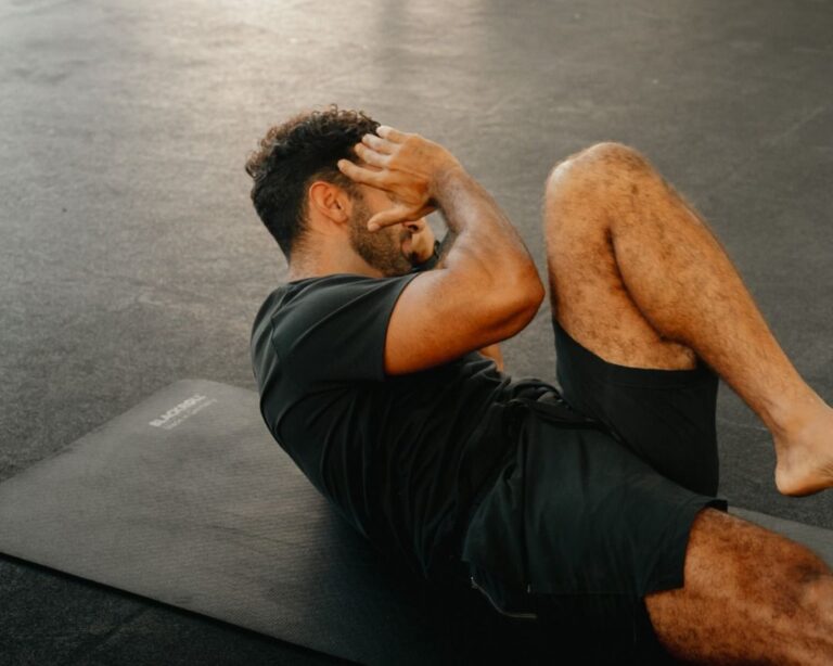Man on an exercise mat doing bicycle crunches.
