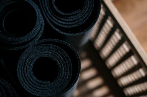 Close-up of rolled yoga mats in a basket at a fitness studio, ideal for yoga or pilates.