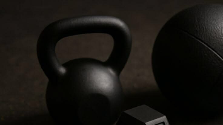 Close-up of dumbbells, kettlebell, and other equipment for a dumbbell home workout.