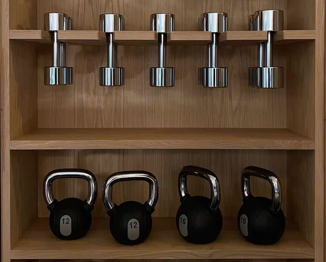home weight set consisting of dumbbells and barbells in home gym storage