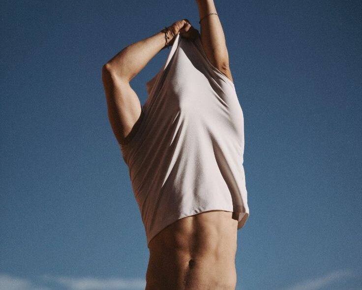 Man taking off shirt and showing abs